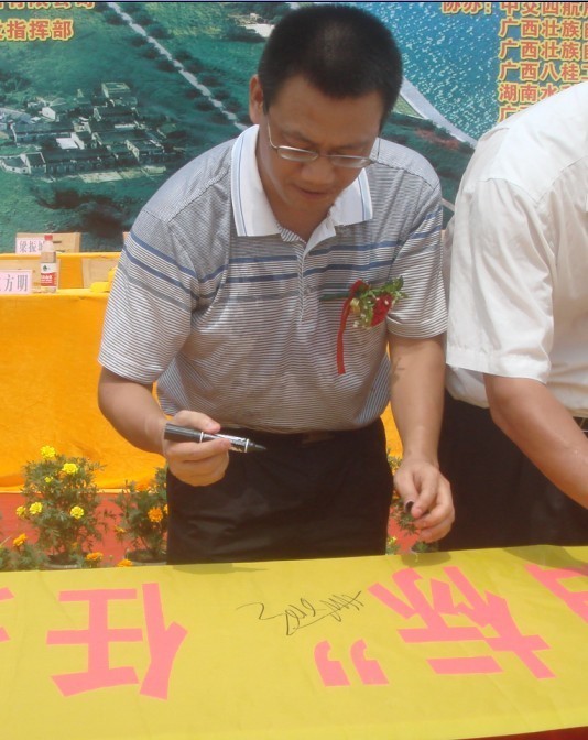 廣西新港灣公司副總經(jīng)理姚方明在“奮戰(zhàn)100天，如期實現(xiàn)魚梁工程截流、通航、發(fā)電‘三大目標’”橫幅上簽字